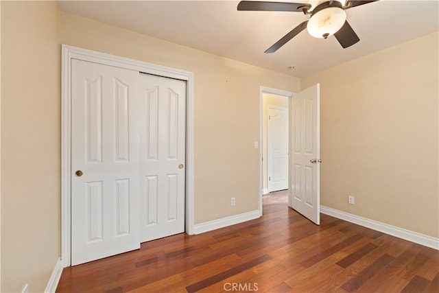 unfurnished bedroom featuring ceiling fan, dark wood-type flooring, and a closet