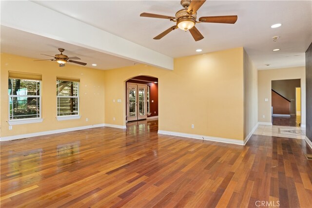 unfurnished living room featuring ceiling fan and hardwood / wood-style flooring