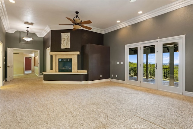 unfurnished living room with ceiling fan, carpet floors, crown molding, and a towering ceiling