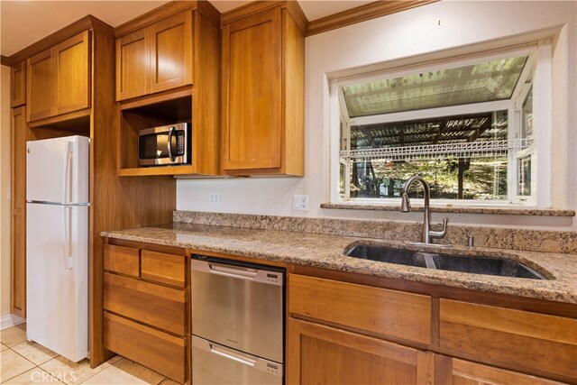 kitchen with sink, stainless steel appliances, light tile patterned floors, crown molding, and light stone countertops