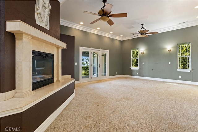 unfurnished living room with ornamental molding, ceiling fan, plenty of natural light, and a fireplace