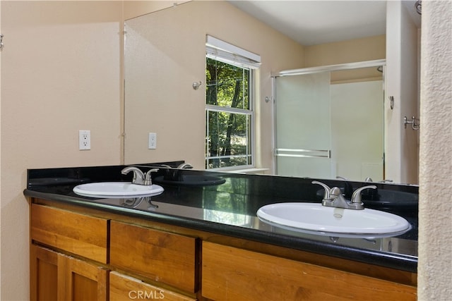 bathroom featuring vanity and a shower with door