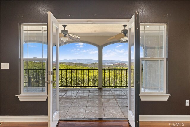 interior space featuring wood-type flooring, a mountain view, and ceiling fan