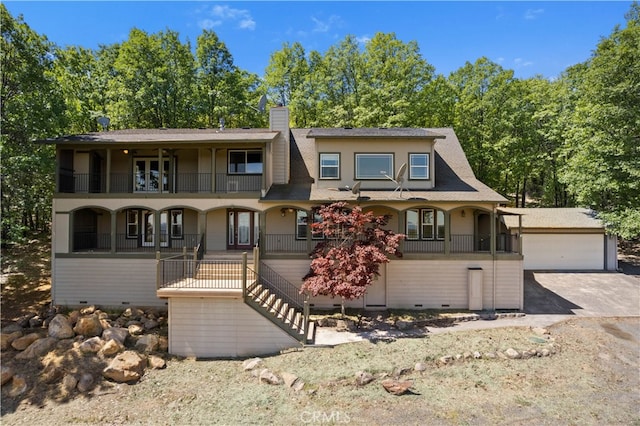 view of front of home with a balcony, a garage, and an outdoor structure