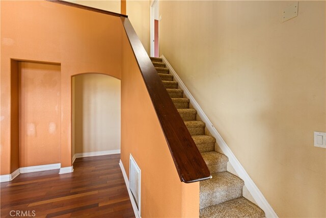 staircase with hardwood / wood-style flooring