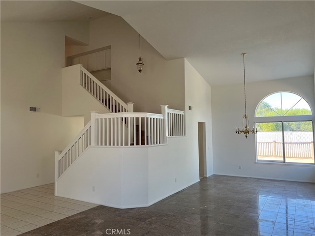 interior space with a chandelier, tile patterned floors, and high vaulted ceiling