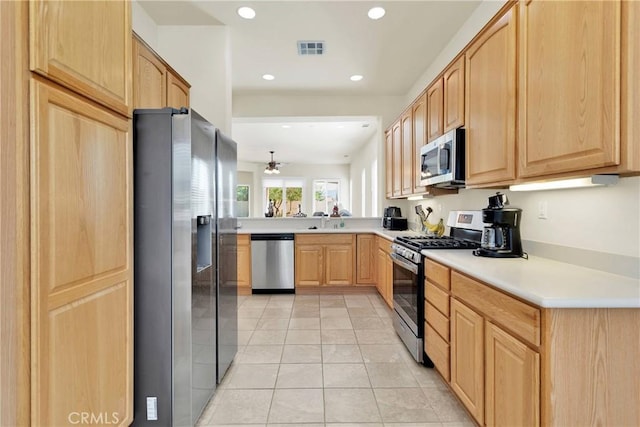 kitchen featuring ceiling fan, sink, stainless steel appliances, light brown cabinetry, and light tile patterned flooring