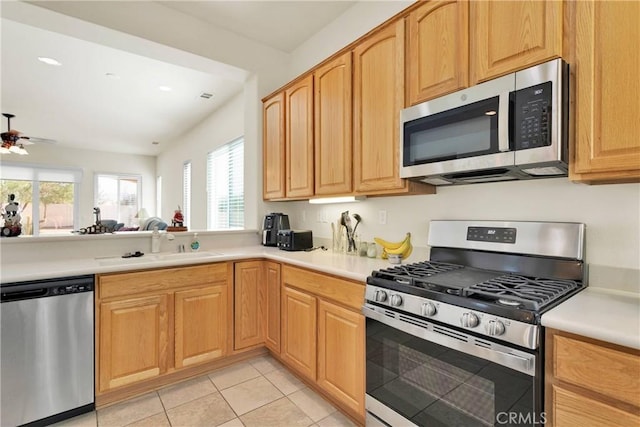 kitchen featuring ceiling fan, sink, light tile patterned floors, and stainless steel appliances