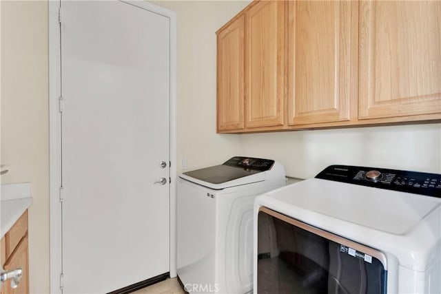 laundry area with washer and dryer and cabinets