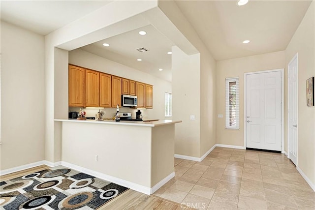 kitchen featuring kitchen peninsula and electric range