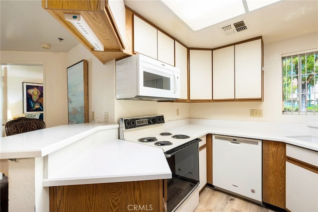 kitchen with kitchen peninsula, white cabinetry, white appliances, and light wood-type flooring