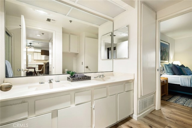 bathroom with hardwood / wood-style flooring, vanity, and ceiling fan