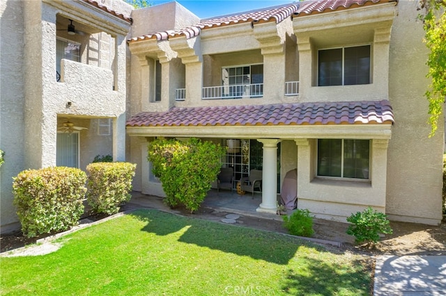 mediterranean / spanish-style home featuring a balcony and a front lawn