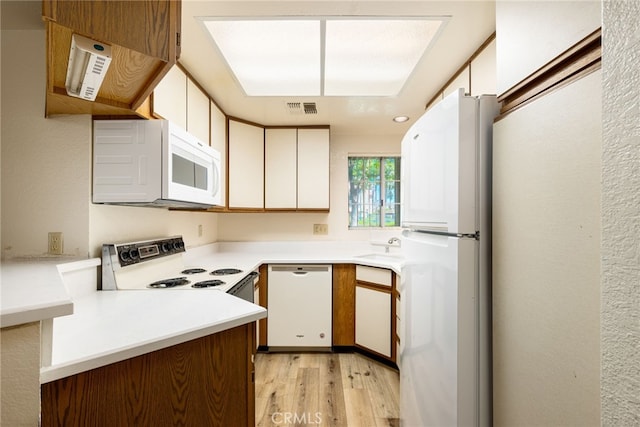 kitchen featuring light wood-type flooring, white appliances, white cabinetry, and sink