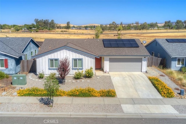 single story home with a garage and solar panels