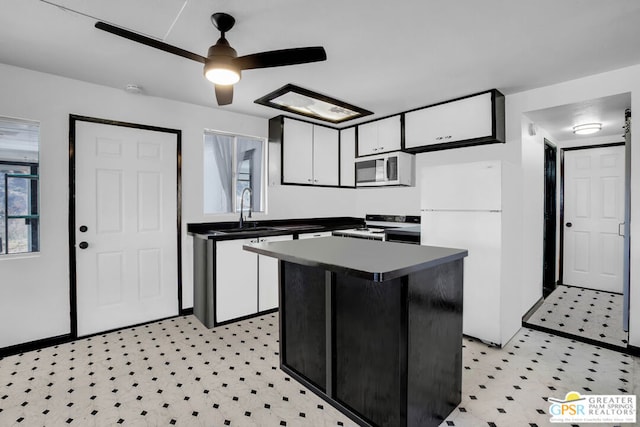 kitchen with white fridge, white cabinets, a kitchen island, sink, and electric range oven