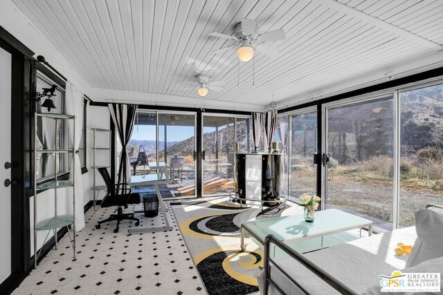 sunroom featuring ceiling fan, wood ceiling, and a mountain view