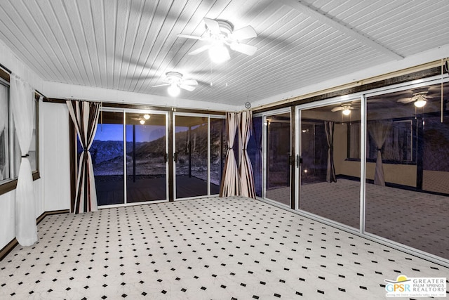 unfurnished sunroom featuring ceiling fan