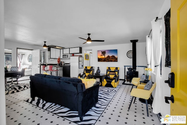 living room with ceiling fan and a wood stove