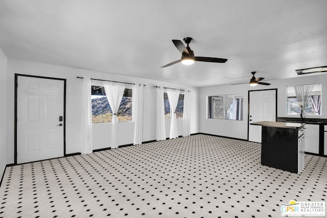 unfurnished living room featuring ceiling fan