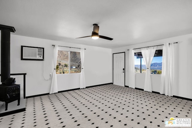 foyer featuring ceiling fan, a wood stove, and a wall mounted air conditioner