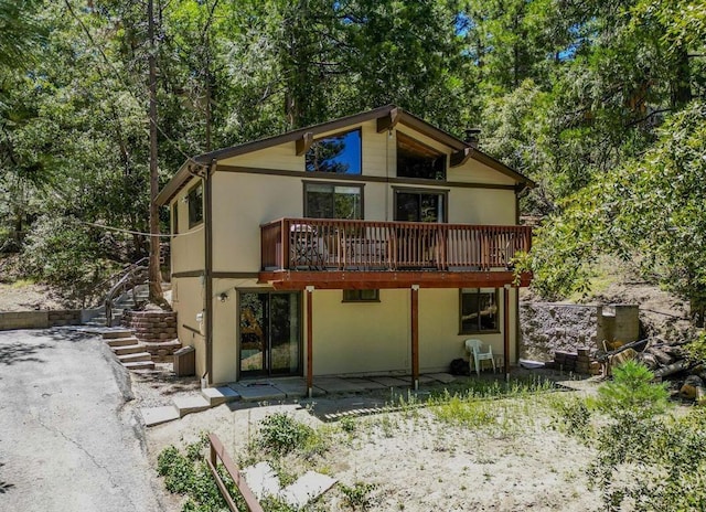 rear view of house featuring a wooden deck