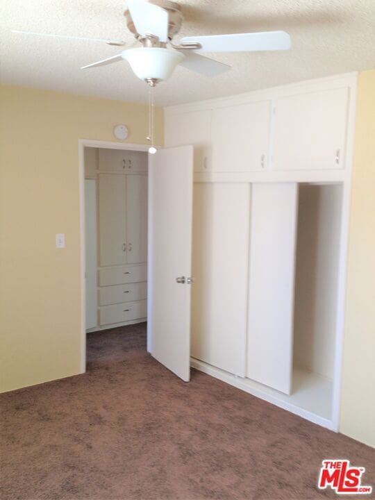 unfurnished bedroom with carpet flooring and ceiling fan