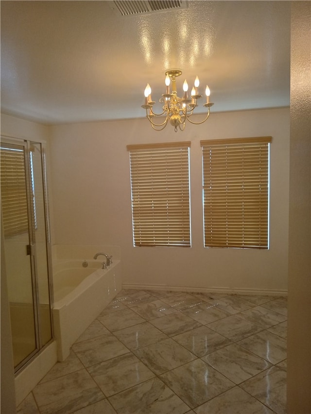 bathroom featuring plus walk in shower and an inviting chandelier