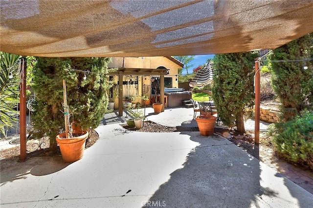 view of patio / terrace featuring a pergola and a hot tub