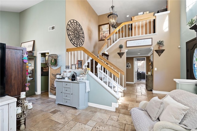 staircase featuring a towering ceiling and a notable chandelier