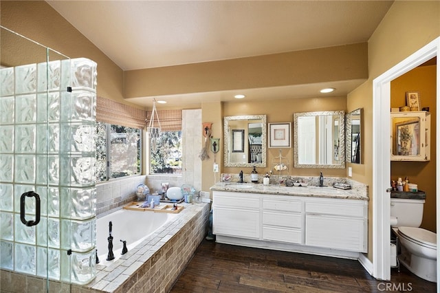 full bathroom featuring hardwood / wood-style floors, vanity, shower with separate bathtub, and toilet