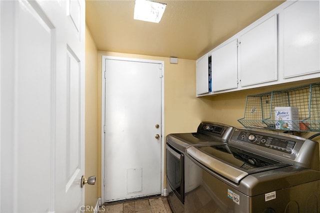 laundry room with separate washer and dryer and cabinets