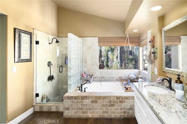 bathroom with hardwood / wood-style floors, vanity, shower with separate bathtub, and vaulted ceiling