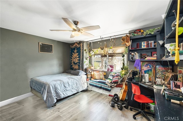 bedroom with hardwood / wood-style floors, ceiling fan, and a wall mounted air conditioner