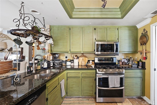 kitchen with dark stone countertops, stainless steel appliances, and green cabinetry