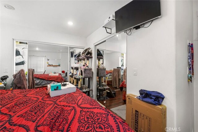 bedroom featuring a closet, wood finished floors, and recessed lighting