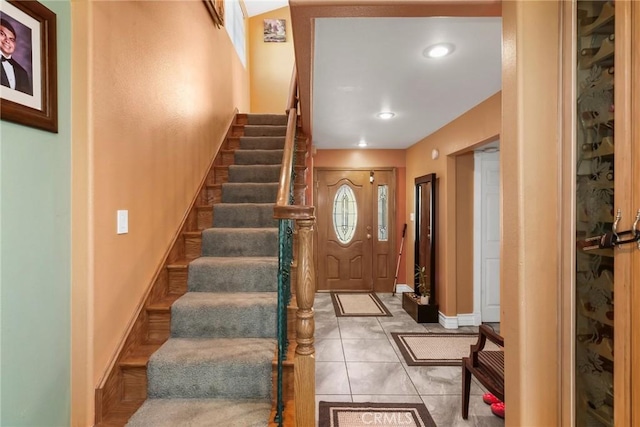 entrance foyer featuring stairs, baseboards, and light tile patterned flooring