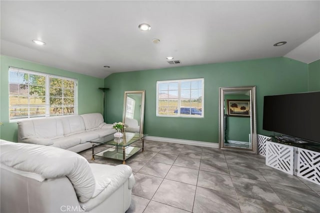 tiled living room featuring vaulted ceiling, visible vents, and a healthy amount of sunlight