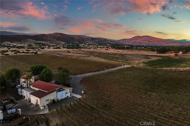 aerial view at dusk featuring a rural view and a mountain view