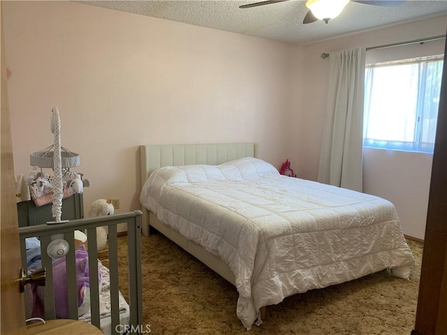 bedroom featuring carpet flooring, a textured ceiling, and ceiling fan