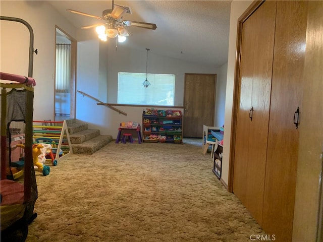 game room with carpet flooring, a textured ceiling, ceiling fan, and lofted ceiling