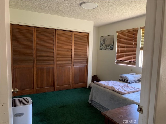 carpeted bedroom featuring a textured ceiling and a closet