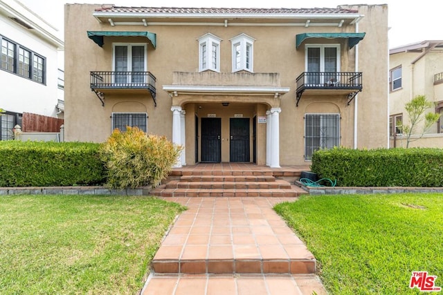 property entrance with french doors, a yard, and a balcony