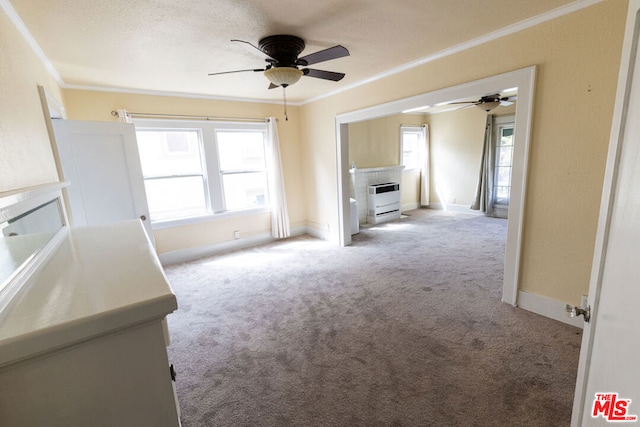 unfurnished living room with light carpet, ornamental molding, heating unit, and a healthy amount of sunlight