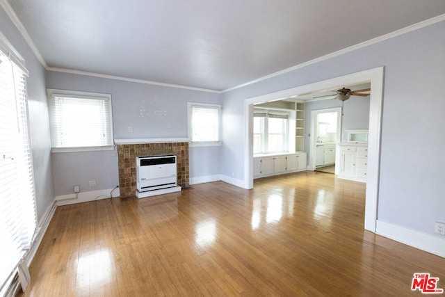 unfurnished living room with ceiling fan, light hardwood / wood-style flooring, a healthy amount of sunlight, and ornamental molding