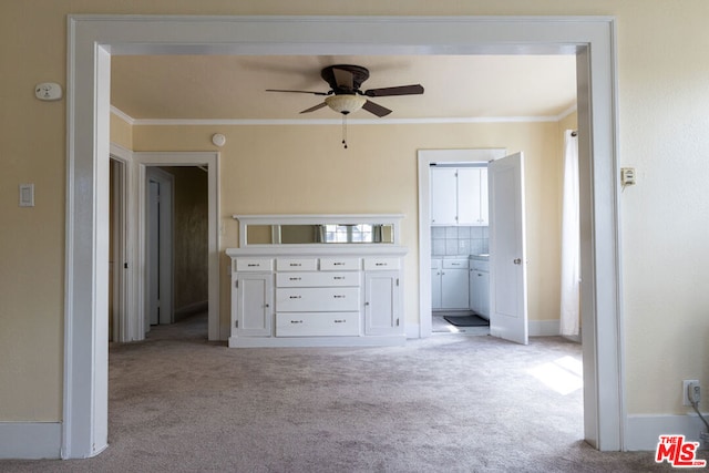 unfurnished bedroom featuring ceiling fan, ornamental molding, and light carpet