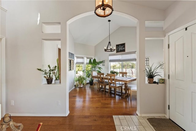 entryway featuring lofted ceiling, dark wood-type flooring, and a chandelier