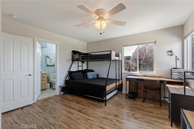 bedroom featuring ceiling fan, connected bathroom, and hardwood / wood-style flooring