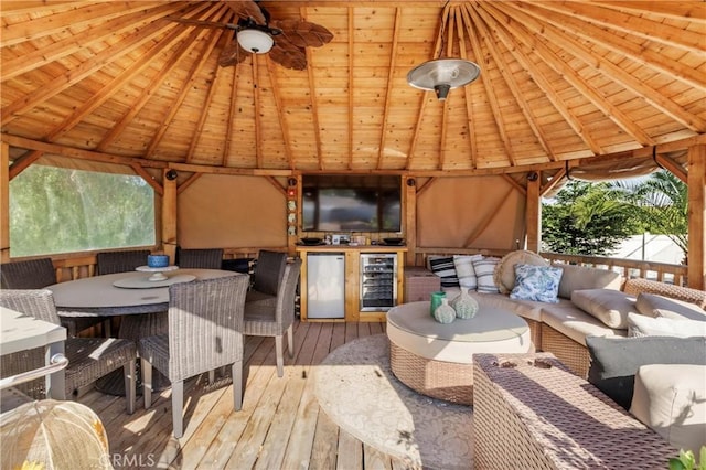 exterior space with ceiling fan, a deck, beverage cooler, and outdoor lounge area