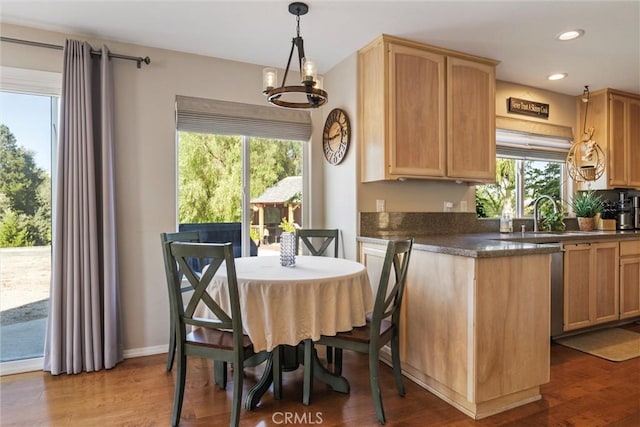 dining area with wood-type flooring, sink, and a chandelier